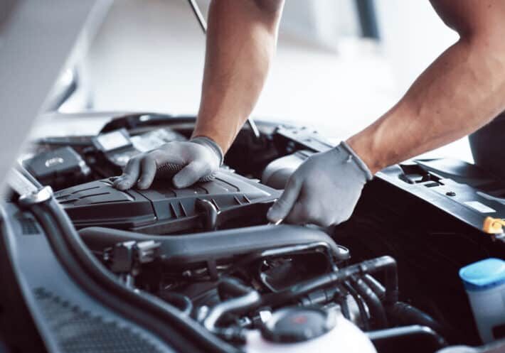 Auto mechanic working in garage. Repair service.