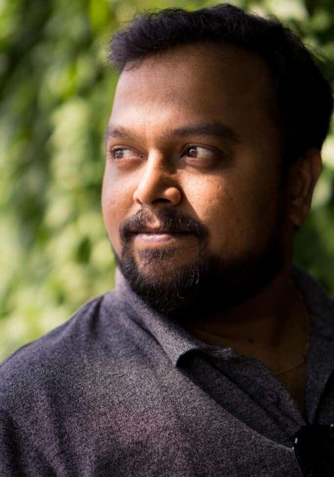 Indian man with beard and moustache portrait with natural light and a green bokeh backround