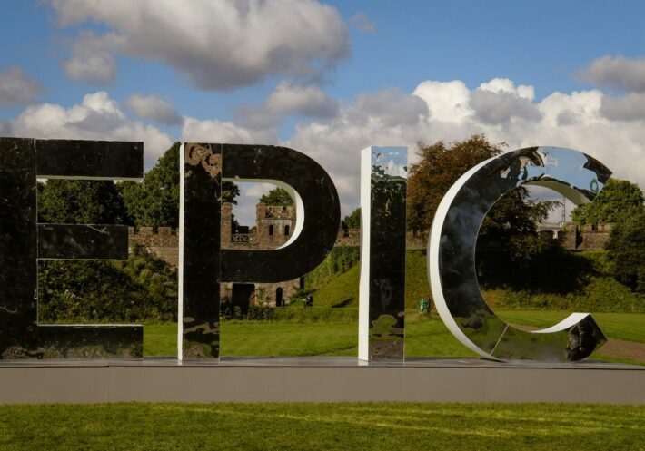 round mirror with reflection of man standing on the ground